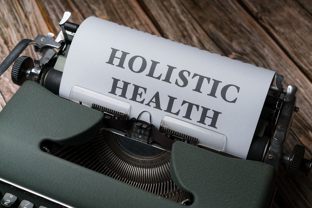 Close-up of a vintage typewriter with Holistic Health on paper, representing wellness.